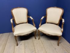 Pair of French show frame style chairs, with cabriole legs, upholstered in a cream fabric, makers