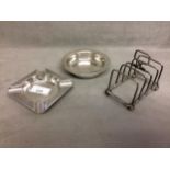 Two sterling silver ashtrays together with a sterling silver toast rack, various dates and makers,