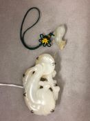 A carved white jade brooch, of an oriental stylized fish, together with a small jade pendent,