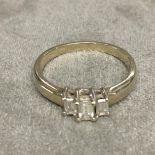 Unmarked white/yellow metal and diamond three stone ring, 3 baguette cut diamonds in prang settings,