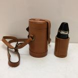 A modern light tan leather hip flask with shoulder strap, the top opening to reveal 3 fitted glass