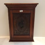Edwardian hanging wall cabinet with carved front panel, possibly oak, and carved floral rosette to