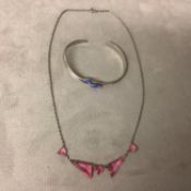 A platinon and pink topaz necklace and a white metal and enamel bangle bracelet, boxed