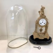 A late C19th French gilt skeleton clock, surmounted by a winged cherub finial, in glass dome and