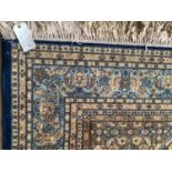 C20th Oriental wool rug, fawn ground with all over fawn and blue floral borders, in used condition