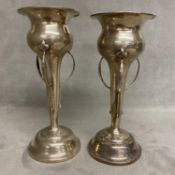 A pair of Arts and Crafts Sterling silver bud vases with three pierced sinuous handles, weighted