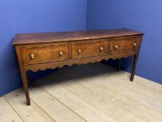 A George III oak dresser base, with three drawers above a shaped frieze, to square tapered legs,