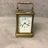 Asprey: a brass carriage clock with French movement, white enamel dial, Roman numeral markers,