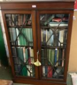 A mahogany and inlaid, astragal glazed bookcase, complete with vintage books of mixed titles,