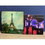 Pair of C20th prints, amodern Parisian Eiffel Tower scene, and an album cover the Orb, both unframed