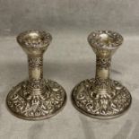 A Pair of Arts and Crafts style sterling silver candlesticks by W J Broadway & Co Birmingham 1924,