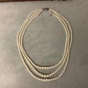 A triple stand of pearls on a diamond set white metal clasp boxed. Largest pearl approx 6mm,