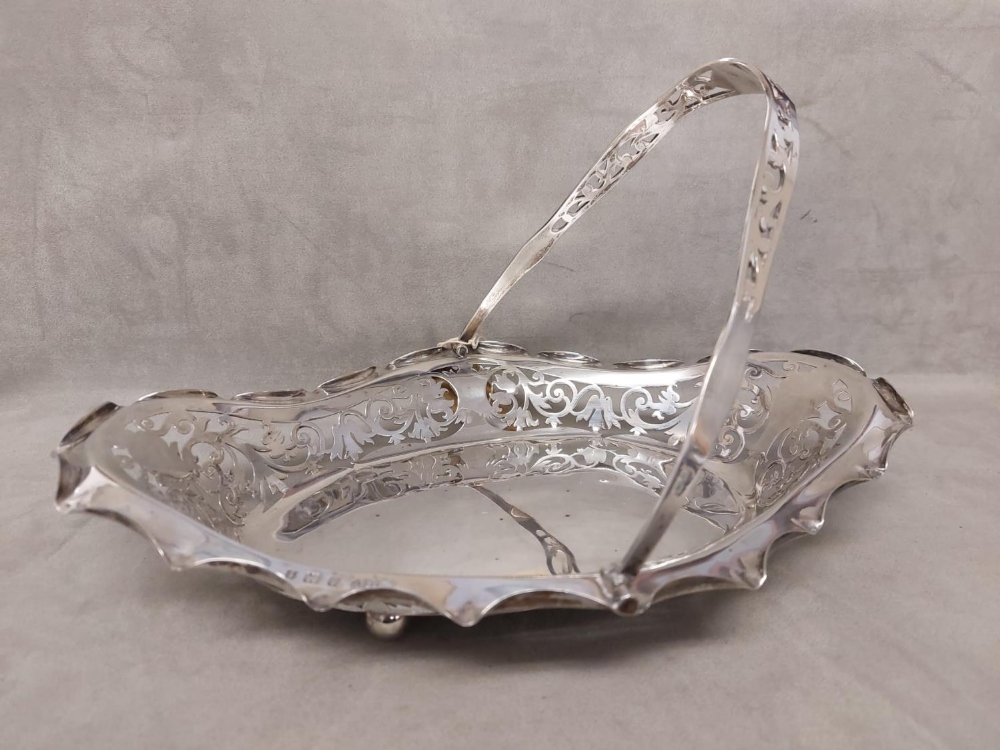 Sterling silver swing handled basket with pierced rim on four ball feet, Joseph Gloster Ltd