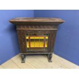 A profusely carved oak cabinet, with central lead and glazed panel