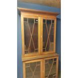 Two part faded mahogany and chequer board inlaid glazed bookcase; as found