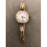 A ladies 9 ct gold wrist watch, on 9ct gold gate link strap, white enamel dial with Arabic and