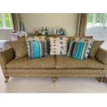 A Durester sofa, upholstered in an olive and gold coloured fabric, on wooden legs to castors; very