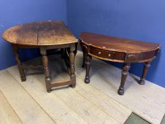 A heavy oak drop leaf dining table and a semi circular side table with central drawer