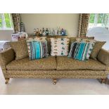 A Durester sofa, upholstered in an olive and gold coloured fabric, on wooden legs to castors; very