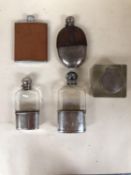 Two sterling silver and glass hip flasks and two white metal and leather mounted hip flasks, and a