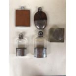 Two sterling silver and glass hip flasks and two white metal and leather mounted hip flasks, and a