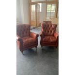 A pair of good tan leather club style arm chairs, with button backs, and brass studded scrolling