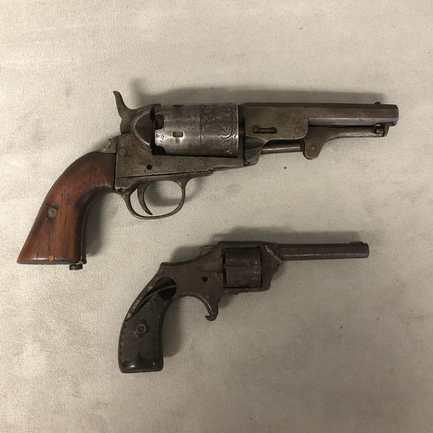 Two C19th obsolete pistols, one with engraved barrel and walnut stock, and a small pin fire