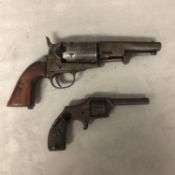 Two C19th obsolete pistols, one with engraved barrel and walnut stock, and a small pin fire