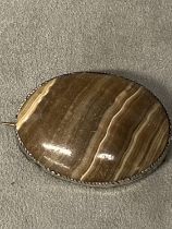 A Scottish oval banded agate brooch in a white metal mount, 62mm x 48mm