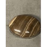 A Scottish oval banded agate brooch in a white metal mount, 62mm x 48mm