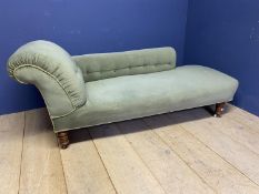 A green upholstered Victorian chaise longue with turned legs to castors