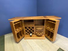 Modern wooden cabinet, opening to reveal a drinks cabinet; on wheels. Vendor purchased it from