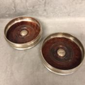 Pair of sterling silver wine bottle coasters by MC Hersey & Son, London, 2001, with turned wooden