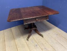 A mahogany fall flap centre breakfast table, with central pedestal to swept reeded legs and brass