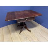 A mahogany fall flap centre breakfast table, with central pedestal to swept reeded legs and brass