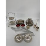 A collection of silver plated items to include coasters, place mats, skewers and other items