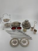 A collection of silver plated items to include coasters, place mats, skewers and other items