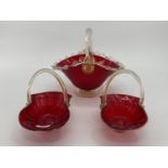 A pair of cranberry glass decorative baskets with rope twist handles, and a larger example