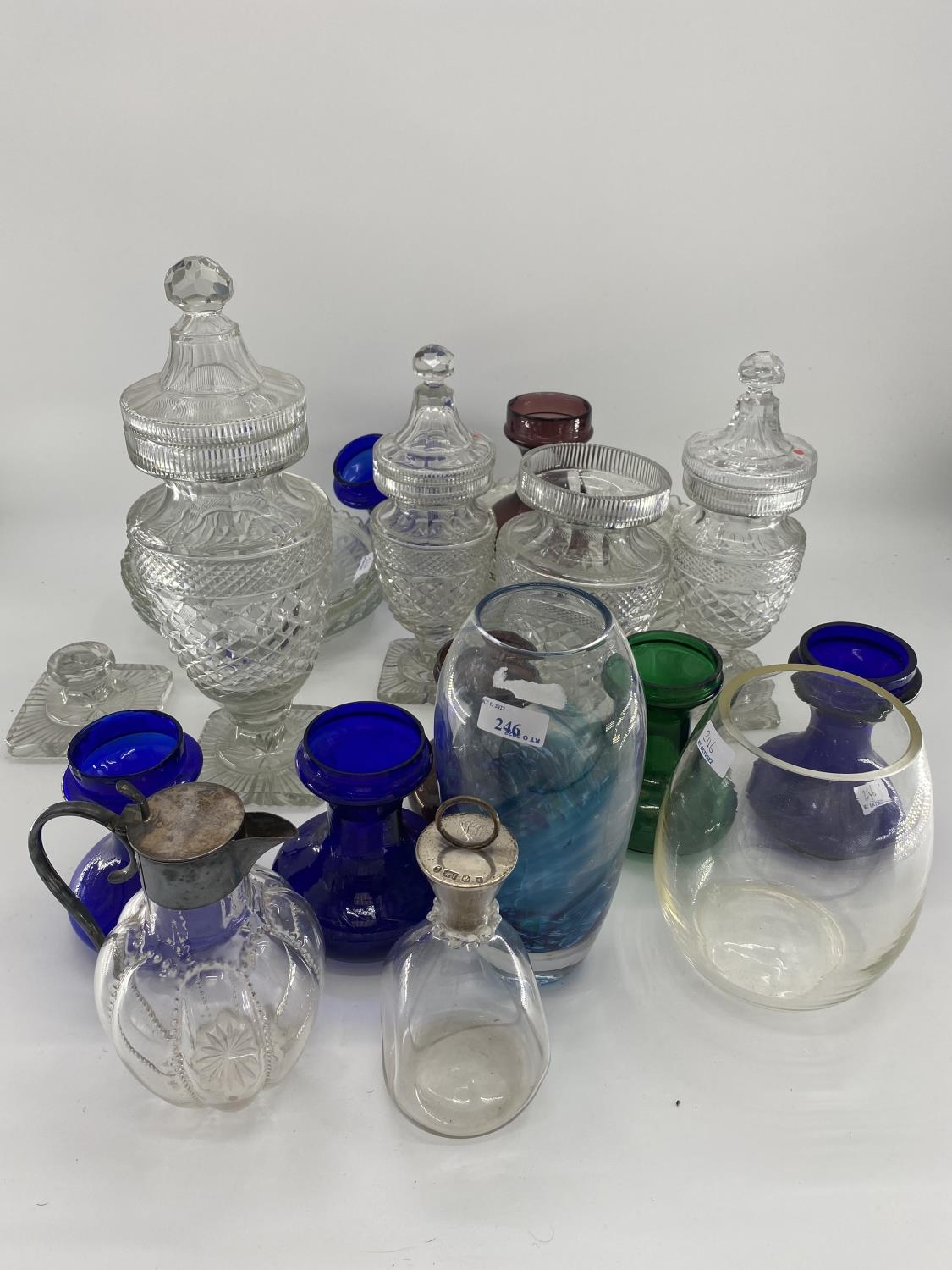 A Stirling silver topped wine carafe together with a white metal topped glass claret jugs, and other