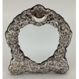 An unmarked white metal easel backed picture frame, shield design with heart shaped aperture, 28 x