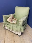 A large open framed arm chair, with floral loose covers, and a smaller arm chair with green loose
