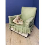 A large open framed arm chair, with floral loose covers, and a smaller arm chair with green loose