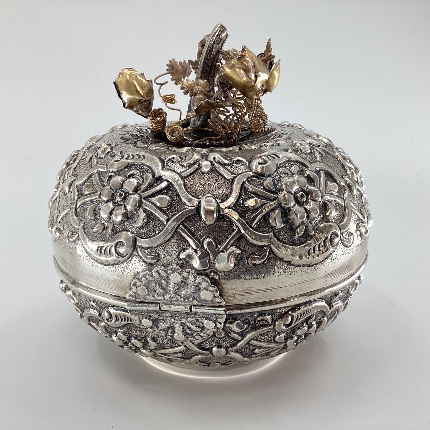 A white metal Middle Eastern style circular casket with raised decoration, gilt floral finial and - Image 5 of 6