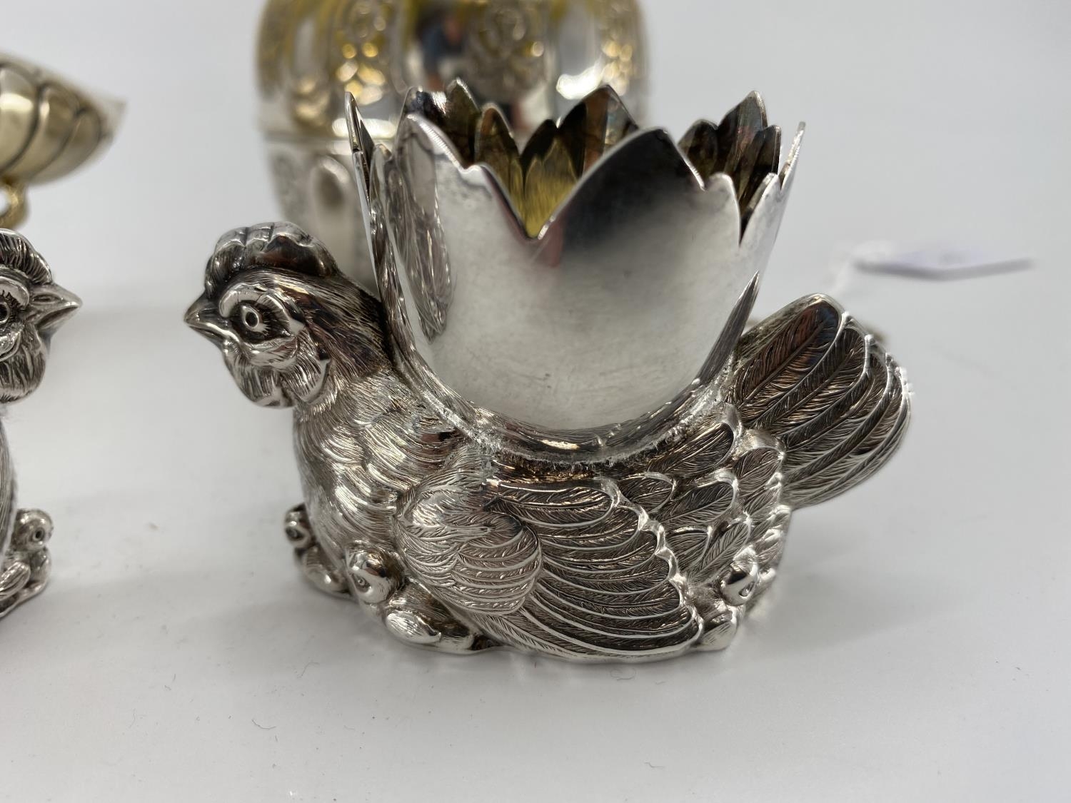 A pair of white metal egg cups in the form of cast chickens with gilt interiors, and a white metal - Image 2 of 5