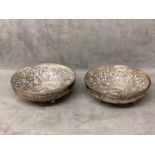 Pair of Middle Eastern white metal bowls with raised floral decoration raised on three feet, 14 x