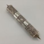 A Middle Eastern style white metal prayer scroll with raised flora and fauna decoration, 30cm,