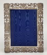 A solid silver pierced easel backed picture frame with cast classical busts and roundels, 30 x 25cm