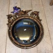 A large late C19th/early C20th circular convex mirror with ball and eagle finials (some losses and