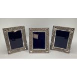 Trio of Turkish silver easel backed picture framed with raised floral and geometric decoration,