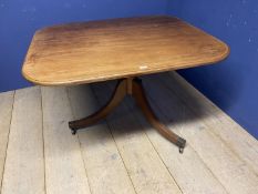 A faded mahogany breakfast table on tripod base swept legs to castors